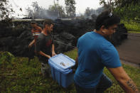 <p>Residents evacuate as lava continues to overrun Hookupu Street, Monday, May 7, 2018, in Pahoa, Hawaii. Hawaii’s Kilauea volcano has destroyed homes and spewed lava hundreds of feet into the air, leaving evacuated residents unsure how long they might be displaced. (Photo: Jamm Aquino/Honolulu Star-Advertiser via AP) </p>