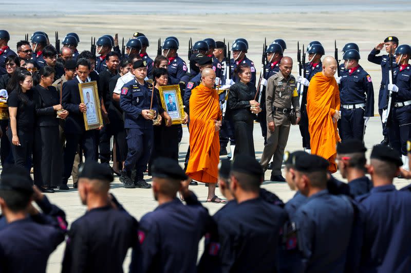 FILE PHOTO: Buddhist monks and families of SWAT members Trakool Tha-arsa and Petcharat Kamjadpai who were killed in a mass shooting at the Terminal 21 shopping mall, are seen at a military airport in Bangkok