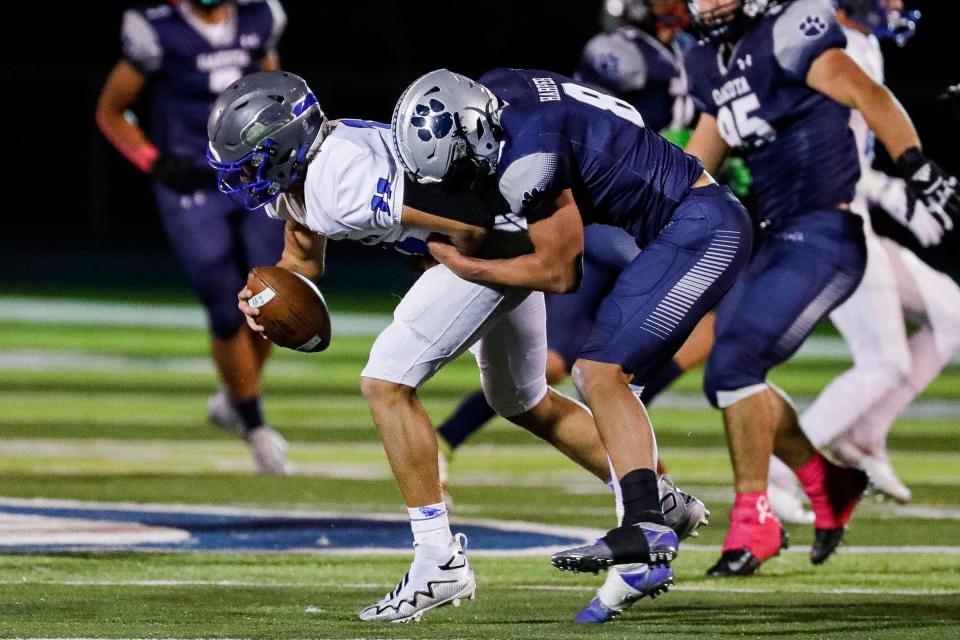 Macomb Dakota linebacker Tyler Harper (8) sacks Utica Eisenhower quarterback Preston Crum (11) during the first half at Dakota High School in Macomb on Friday, Oct. 7, 2022.