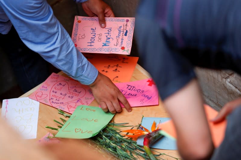 Relatives put cards on top of one of the coffins during the burial of Rhonita Miller and her children Howard, Kristal, Titus, and Teana, who were killed by unknown assailants, in LeBaron