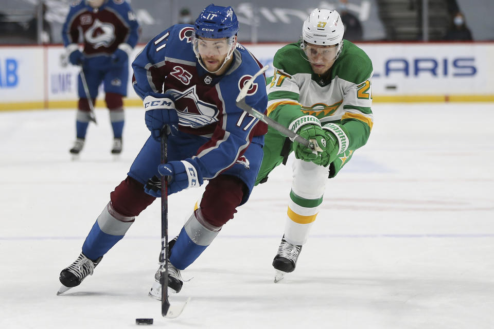 Colorado's Tyson Jost (17) handles the puck against Minnesota Wild's Nick Bjugstad (27) in the second period of an NHL hockey game Sunday, Jan. 31, 2021, in St. Paul, Minn. (AP Photo/Stacy Bengs)