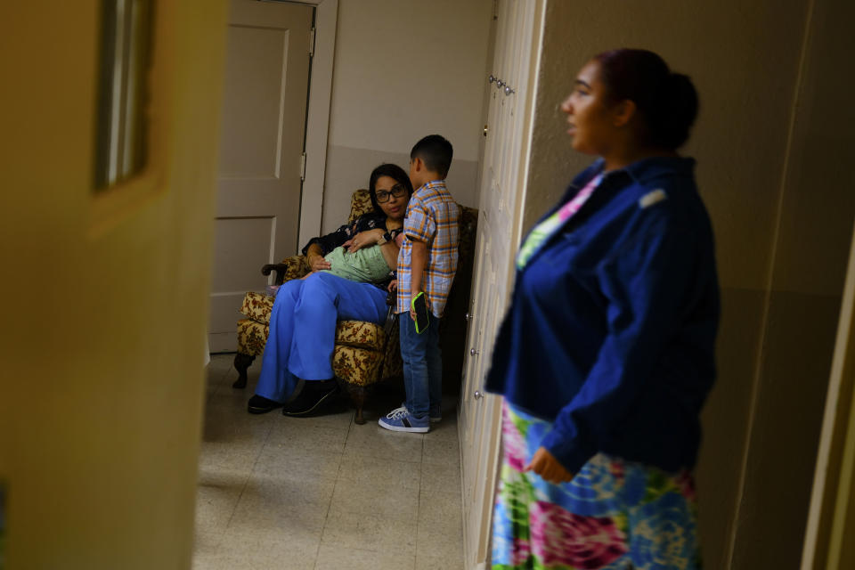 A parishioner holds her daughter in her arms and talk to a child at Iglesia Jesucristo es el Rey (Church Jesus Christ is the King), a thriving Latino congregation that shares the building with First Baptist Church in Reading, Pa., Sunday June 9, 2024. (AP Photo/Luis Andres Henao)