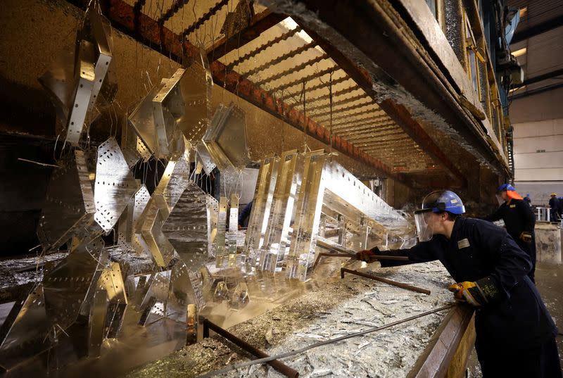 Worker removes pieces of metal from the galvanising bath inside the factory of Corbetts The Galvanizers in Telford