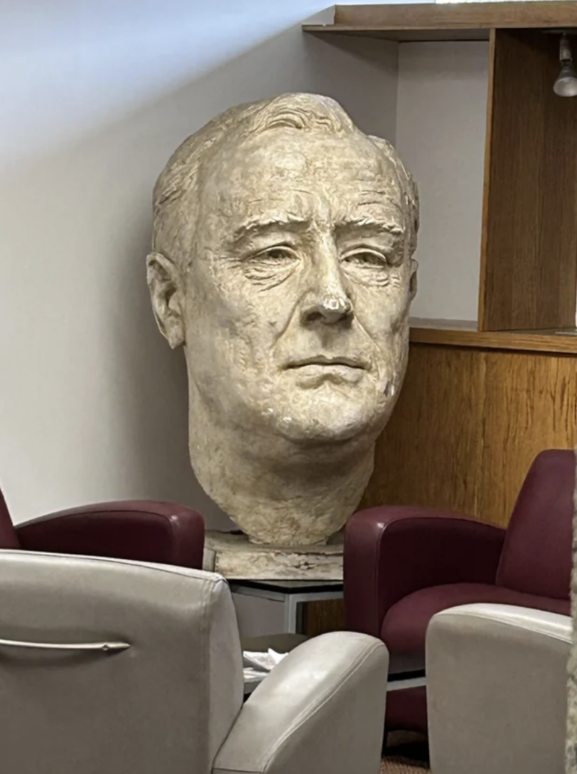 A large sculpture of Franklin D. Roosevelt's head displayed in an indoor setting