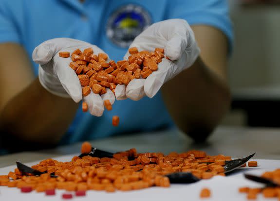 A drug enforcement agent in the Philippines shows illegal ecstasy pills seized in Manila, Sept. 14, 2016.