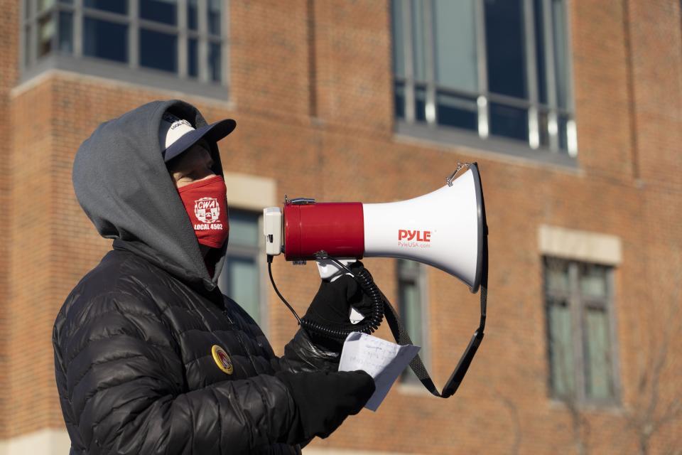 Mark Stansberry, left, a member of the Communication Workers of America Local 4502, speaks Friday at a protest outside the Student Union by Ohio State student workers who want the university to raise the minimum wage for student workers to $15 an hour.