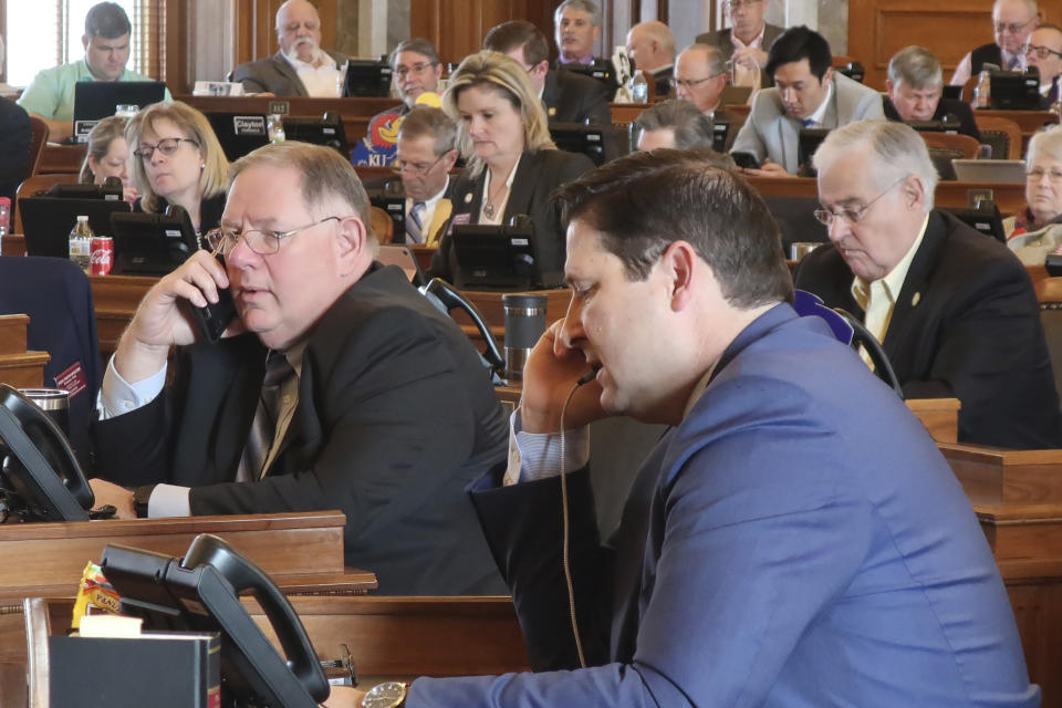 Kansas House Majority Leader Dan Hawkins, center left, R-Wichita, and House Speaker Ron Ryckman Jr., center right, R-Olathe, work the phones during a House vote on a proposed amendment to the state constitution on abortion, Friday, Feb. 7, 2020, at the Statehouse in Topeka, Kansas. Hawkins and Ryckman were trying to round up the final votes needed to pass the proposed amendment, which overturns a Kansas Supreme Court decision declaring access to abortion a "fundamental" right under the state's Bill of Rights. (AP Photo/John Hanna)