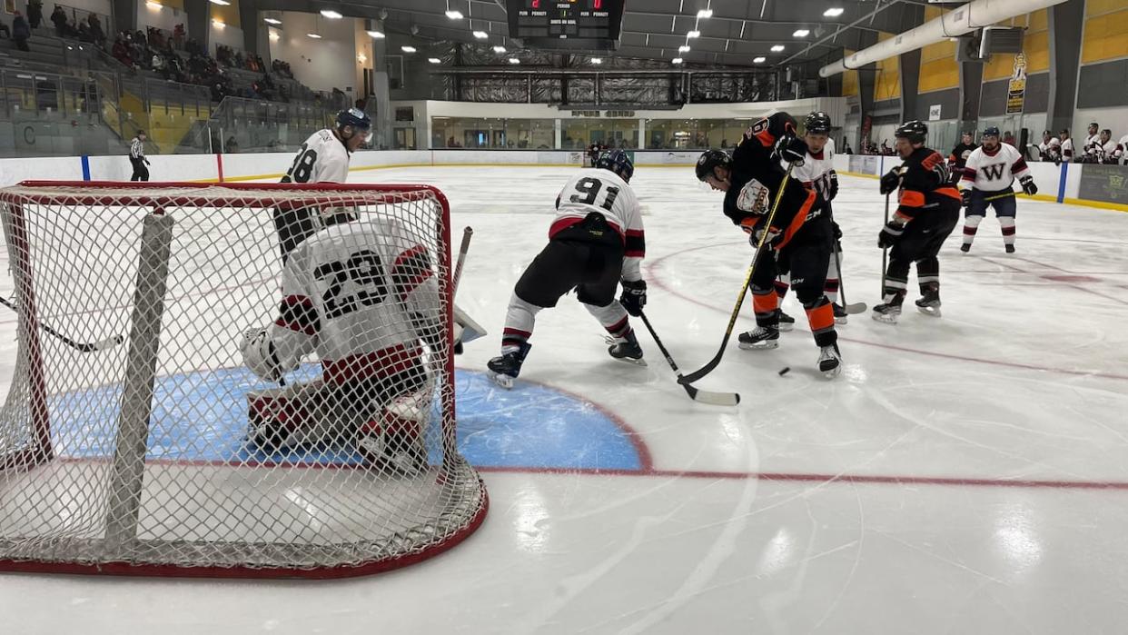 Team Todd, in black, is trying to repeat as B Division champions at this year's Terence Tootoo Memorial Tournament in Rankin Inlet, Nunavut. The tournament continues through this weekend.  (Cameron MacIntosh/CBC  - image credit)