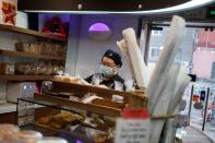 A staff member wearing a mask works at a cafe of the French bakery Comptoirs de France, as the country is hit by an outbreak of the novel coronavirus, in Beijing