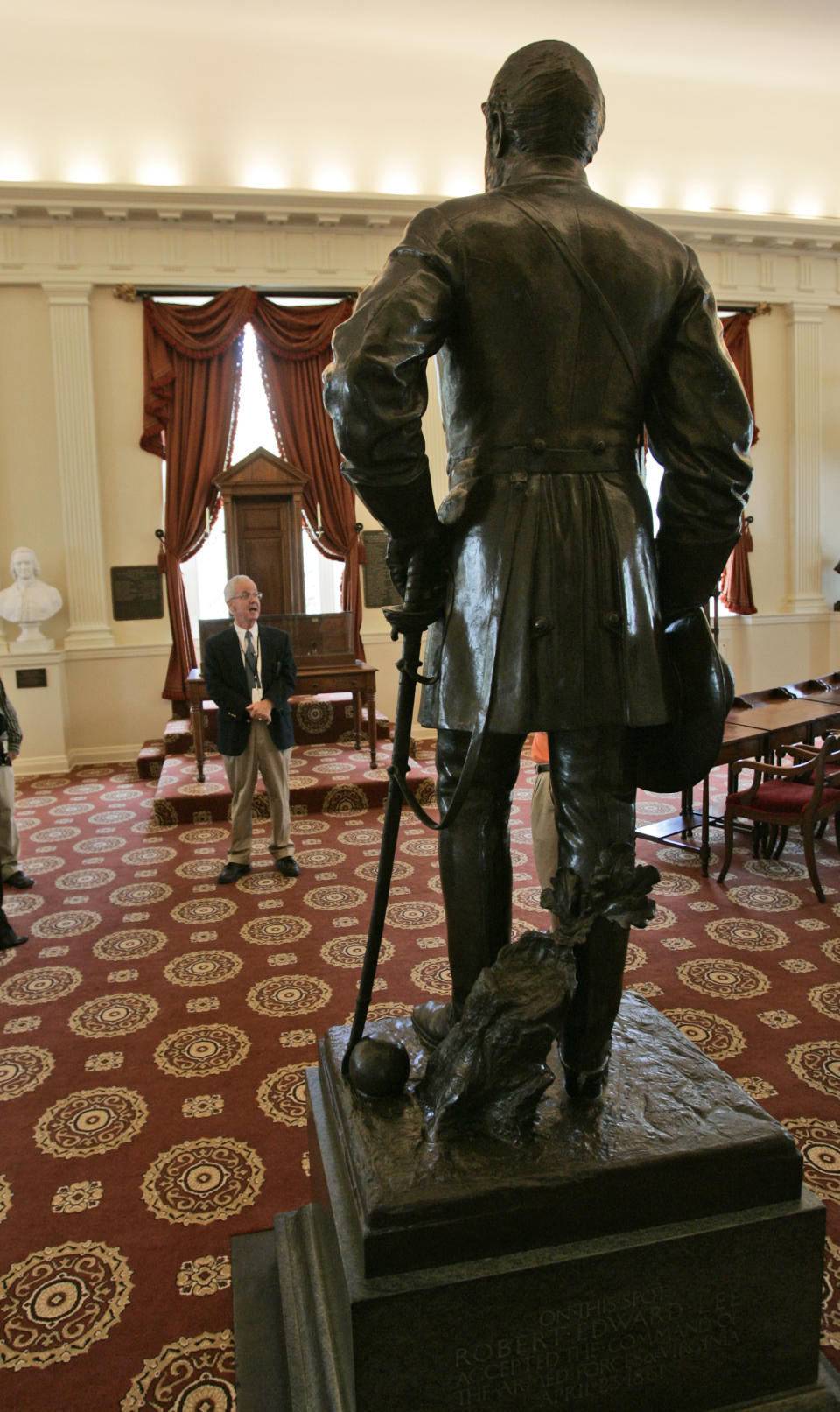 FILE - In this Aug. 9, 2007 file photo, a tour guide leads a tour in the Old Senate Chambers at the State Capitol in Richmond, Va. The Capitol reopened in 2007 after a $104.5 million restoration and expansion project that began in 2004. Statues of Virginia historic figures dot the grounds. (AP Photo/Steve Helber)