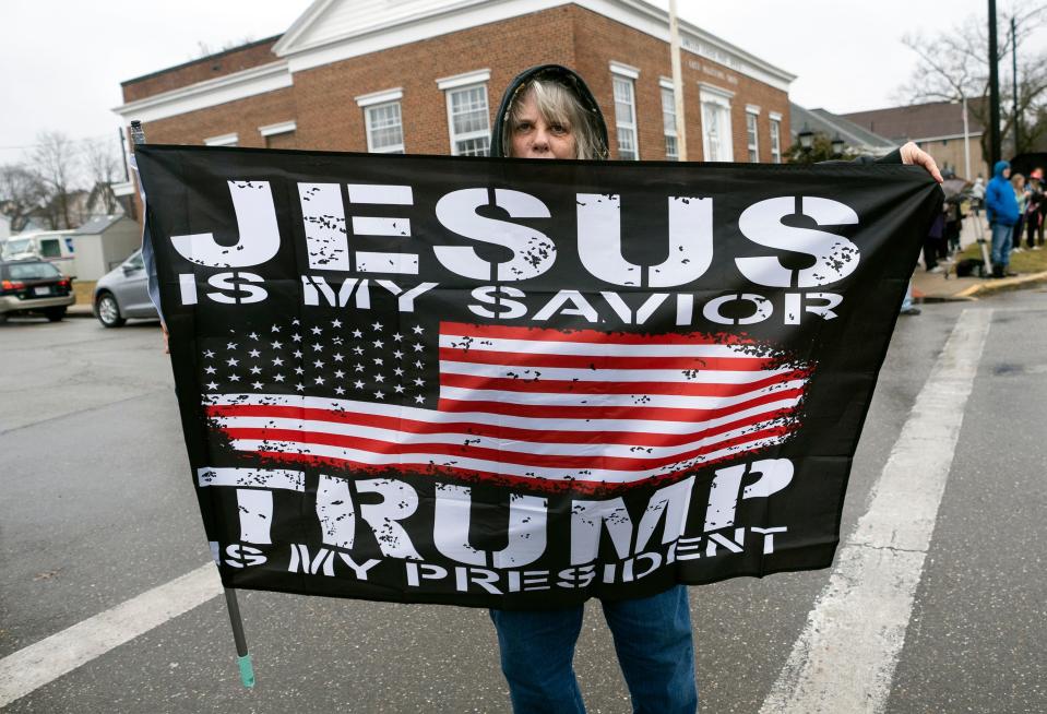 Feb 22, 2023; East Palestine, Ohio, USA; Pam Coleman holds a flag while waiting to see former President Donald Trump arrive in a motorcade. Mandatory Credit: Brooke LaValley/Columbus Dispatch