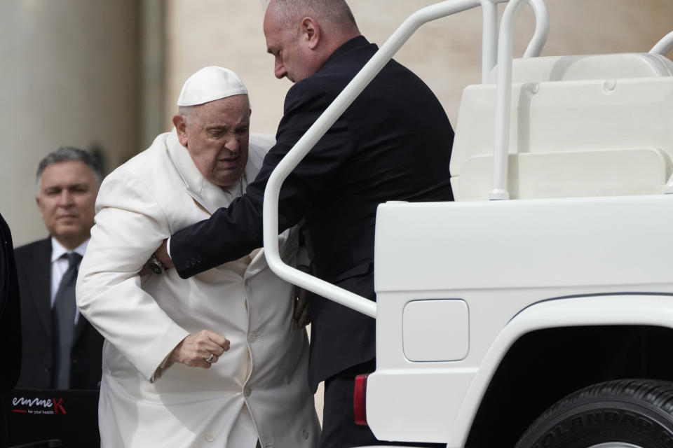 Pope Francis helped to get on his car at the end of weekly general audience in St. Peter's Square, at the Vatican, Wednesday, March 29, 2023. Pope Francis went to a Rome hospital on Wednesday for some previously scheduled tests, slipping out of the Vatican after his general audience and before the busy start of Holy Week this Sunday. (AP Photo/Alessandra Tarantino)