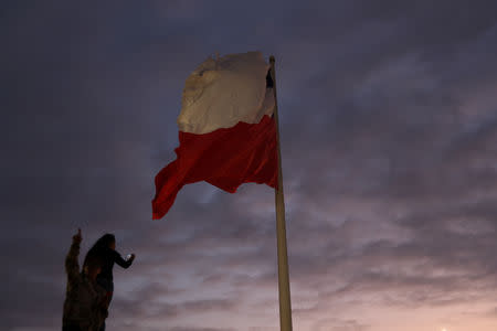 A flag waves as foreigners visit the Morro de Arica national monument, near the Chilean and Peruvian border, in Arica, Chile, November 15, 2018. REUTERS/Ivan Alvarado