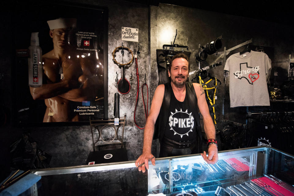 Rod Caldwell, co-owner of Spike's Leather Club in Birmingham, Alabama, stands behind a glass counter in their boutique. 