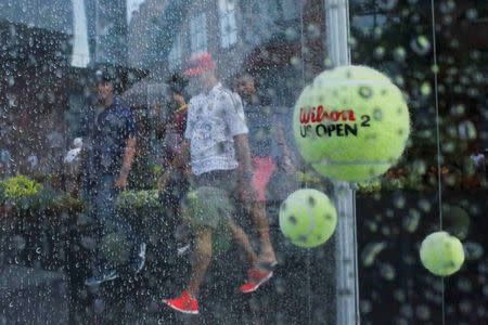 Decorative tennis balls hang on wires in the rain as quarterfinals play between Simona Halep of Romania and Victoria Azarenka of Belarus is suspended due to weather at the U.S. Open Championships tennis tournament in New York, September 9, 2015. REUTERS/Eduardo Munoz