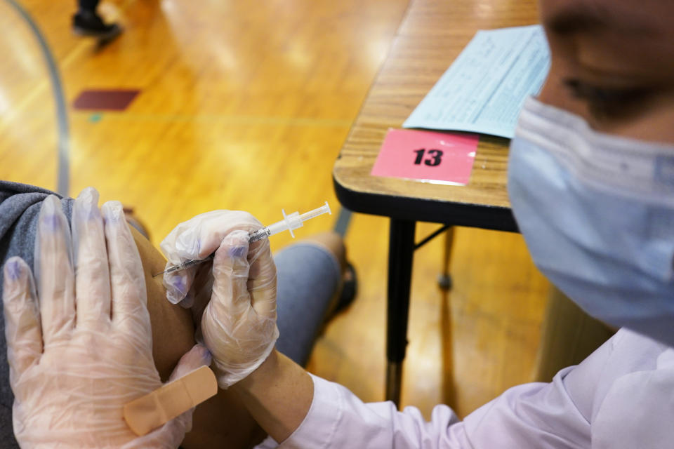 FILE - In this June 11, 2021, file photo, healthcare worker prepares inject a student with a dose of the Pfizer COVID-19 vaccine during a vaccination clinic hosted by Jewel Osco at London Middle School in Wheeling, Ill. As cases fall and states reopen, the potential final stage in the U.S. campaign to vanquish COVID-19 is turning into a slog, with a worrisome variant gaining a bigger foothold and lotteries and other inducements failing to persuade some Americans to get vaccinated. (AP Photo/Nam Y. Huh, File)