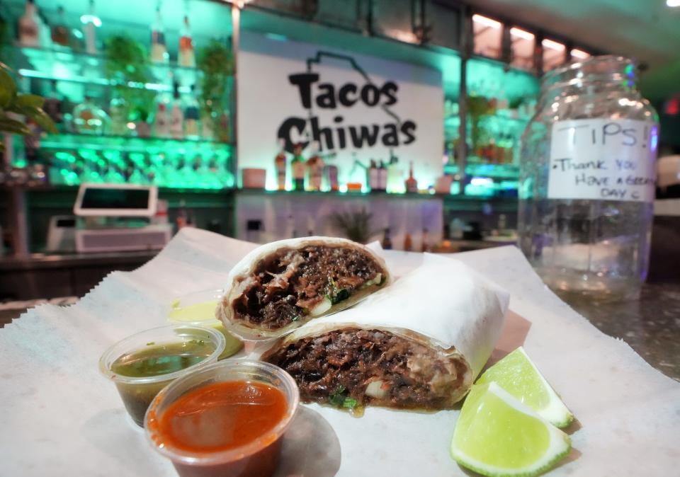 Tacos Chiwas barbacoa burrito with shredded beef cheek, cilantro and white onion.