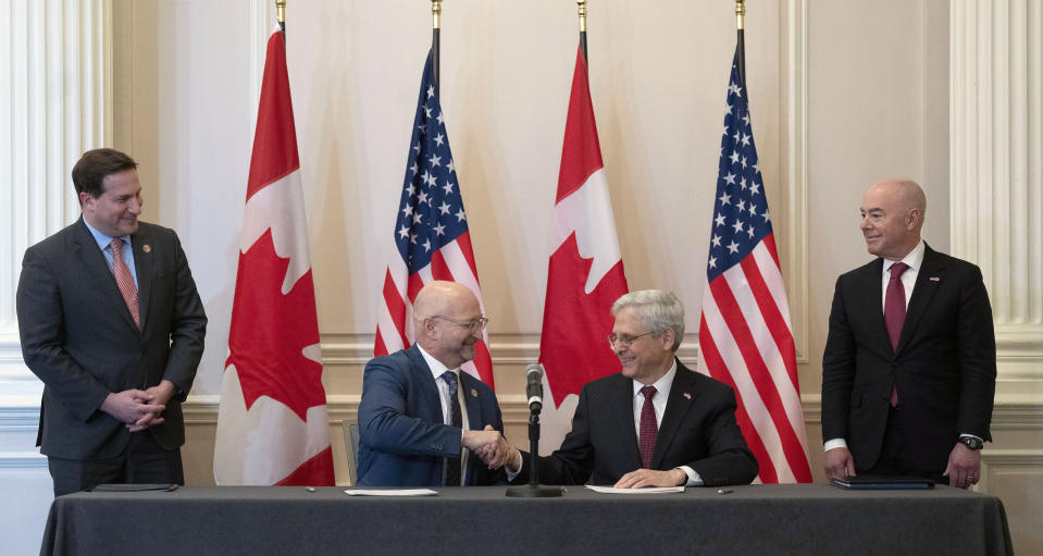 Public Safety Minister Marco Mendicino, left, and U.S. Secretary of Homeland Security Alejandro Mayorkas, right, look on as Minister of Justice and Attorney General of Canada David Lametti, center left and U.S. Attorney General Merrick Garland shake hands after signing a document following the 2023 Canada-United States Cross-Border Crime Forum, Friday, April 28, 2023 in Ottawa, Ontario. (Adrian Wyld/The Canadian Press via AP)