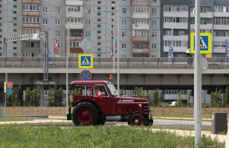 Three Swiss fans arrive in an old-time tractor from home to Kaliningrad stadium, to watch their team playing against Serbia, in Kaliningrad, Russia June 21, 2018. REUTERS/Mariana Bazo