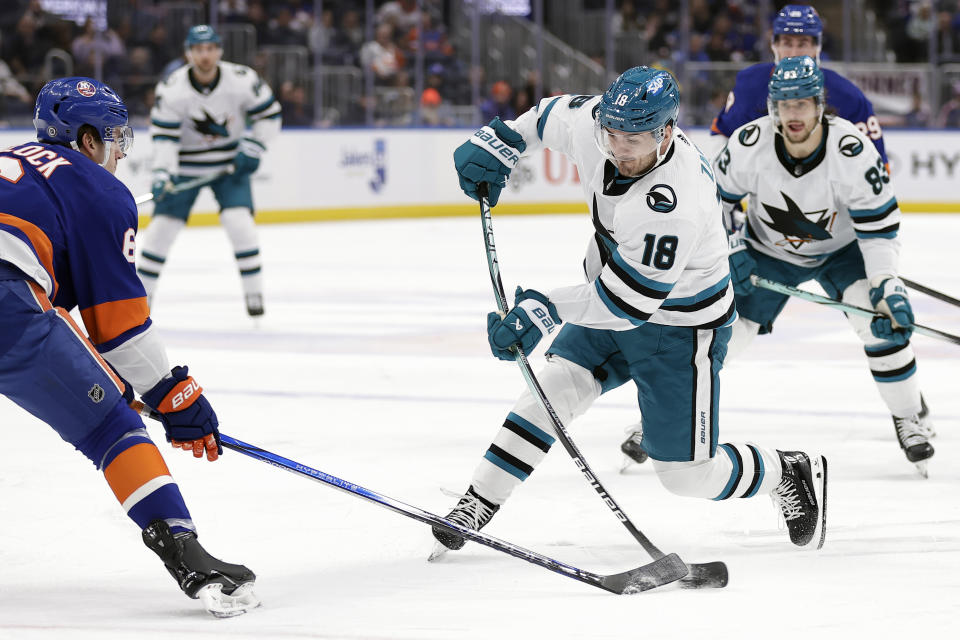 San Jose Sharks right wing Filip Zadina (18) shoots in front of New York Islanders defenseman Ryan Pulock during the first period of an NHL hockey game Tuesday, Dec. 5, 2023, in Elmont, N.Y. (AP Photo/Adam Hunger)