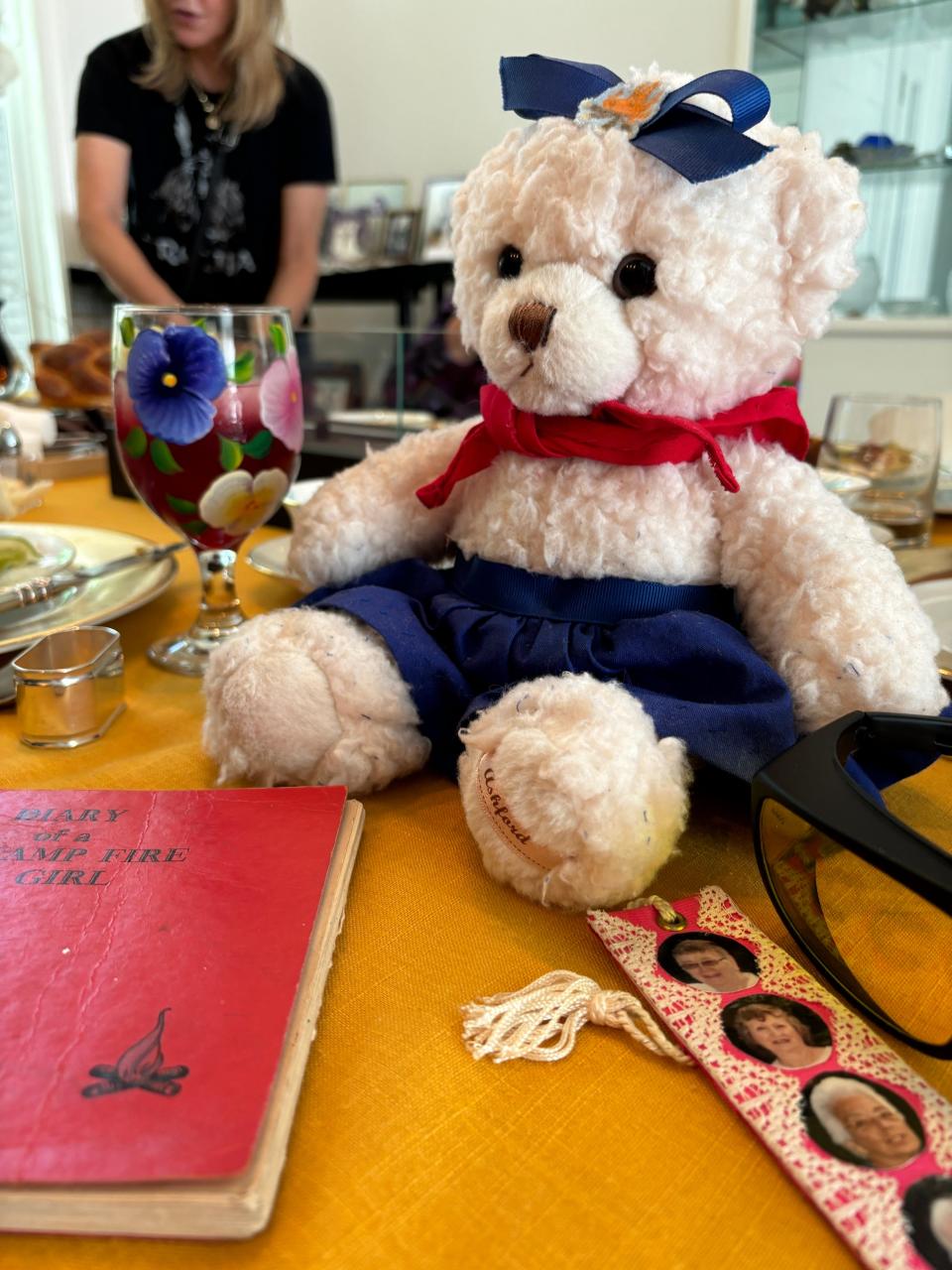 A diary of a former Camp Fire Girl (left), Evelyn Mintzer's teddy bear that Caryl Calsyn made after her stroke, and a bookmark with several Camp Fire Girls on it.