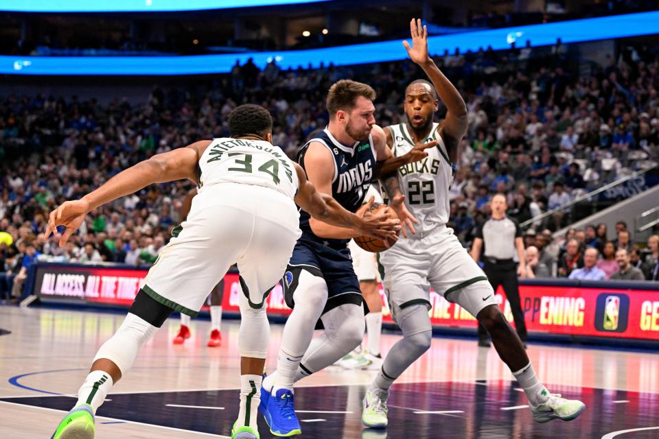 Mavericks guard Luka Doncic drives to the basket between Bucks forwards Giannis Antetokounmpo and Khris Middleton during the first quarter Friday night.