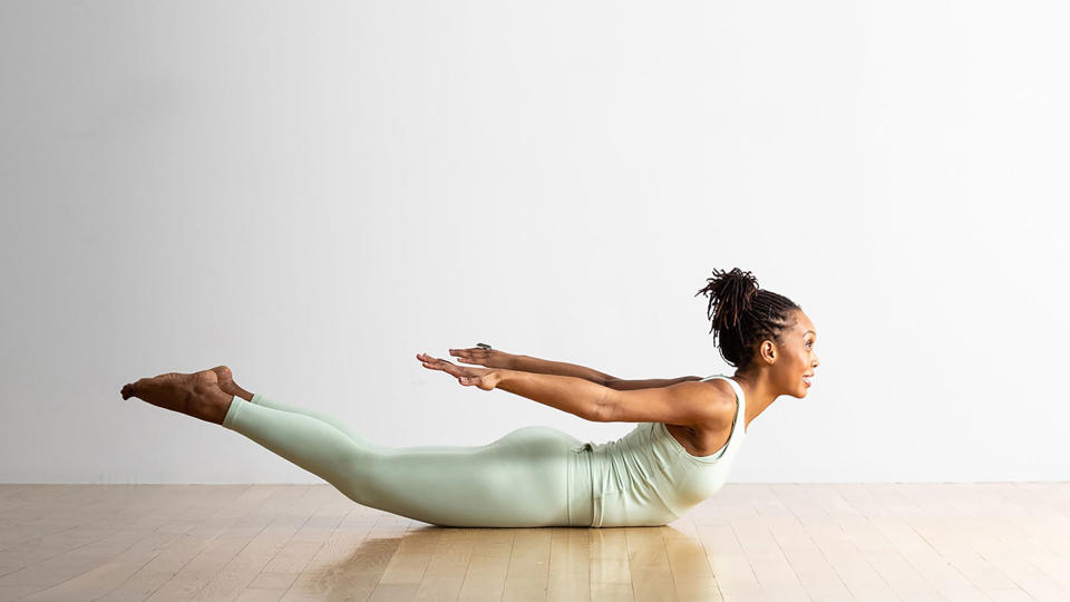 A person demonstrates Salabhasana (Locust Pose) in yoga