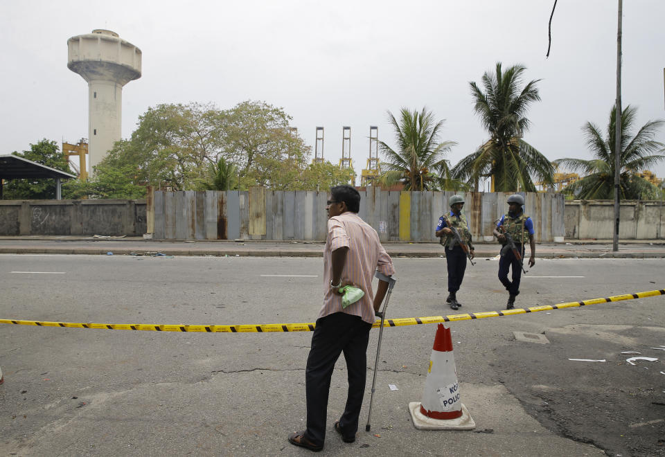 A Sri Lankan man looks at a blocked road leading to St. Anthony's Church as Naval soldiers patrol, in Colombo, Sri Lanka, Monday, April 29, 2019. The Catholic Church in Sri Lanka says the government should crack down on Islamic extremists with more vigor "as if on war footing" in the aftermath of the Easter bombings. (AP Photo/Eranga Jayawardena)