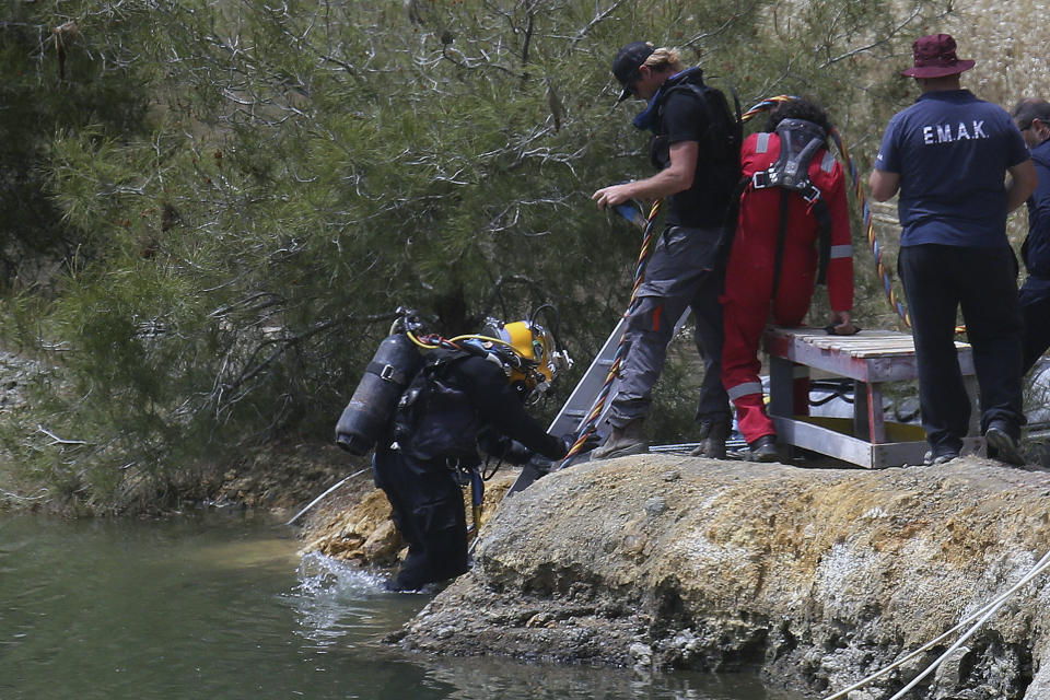 A diver enters a lake to search for female bodies in the near village of Xiliatos outside of capital Nicosia, Cyprus, Friday, April 26, 2019. Cyprus police are intensifying a search for the remains of more victims at locations where an army officer _ who authorities say admitted to killing five women and two girls - had dumped their bodies. (AP Photo/Petros Karadjias)
