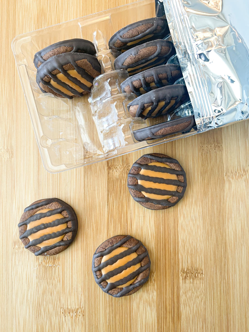 Three Adventurefuls cookies laid out on a table next to the plastic carton