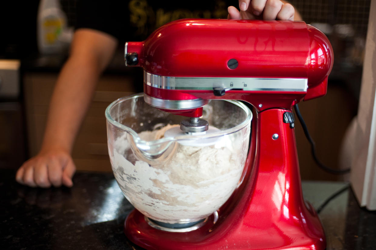 A red stand mixer, mixing a dough