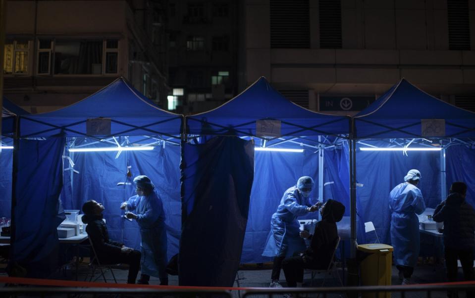 Health workers administer Covid-19 test outside a building placed under lockdown at the City Garden housing estate in the North Point district in Hong Kong - Louise Delmotte/Bloomberg