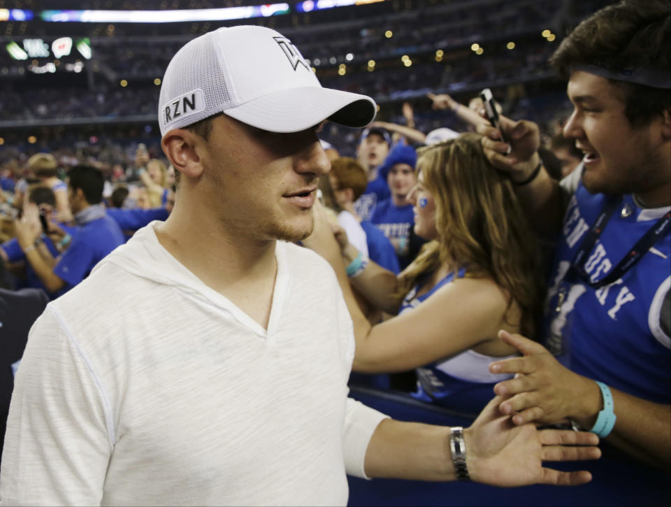 Former Texas A&M football quarterback Johnny Manziel greets fans during halftime of the NCAA Final Four tournament college basketball semifinal game between Wisconsin and Kentucky Saturday, April 5, 2014, in Arlington, Texas. (AP Photo/David J. Phillip)