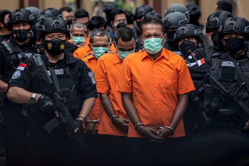 Indonesia Police officers escort suspected drug smugglers during media conference in Jakarta