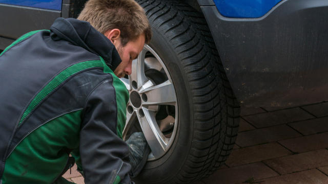 Young man exchanging the car tires. (Getty Images)