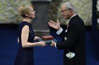 Jenny Munro, daughter of Canadian author Alice Munro, collects the Nobel Prize in Literature on behalf of her mother, from Sweden's King Carl Gustaf during the 2013 Nobel Prize award ceremony in Stockholm December 10, 2013. REUTERS/Claudio Bresciani/TT News Agency (SWEDEN - Tags: SOCIETY ROYALS) ATTENTION EDITORS - THIS IMAGE WAS PROVIDED BY A THIRD PARTY. THIS PICTURE IS DISTRIBUTED EXACTLY AS RECEIVED BY REUTERS, AS A SERVICE TO CLIENTS. SWEDEN OUT. NO COMMERCIAL OR EDITORIAL SALES IN SWEDEN. NO COMMERCIAL SALES