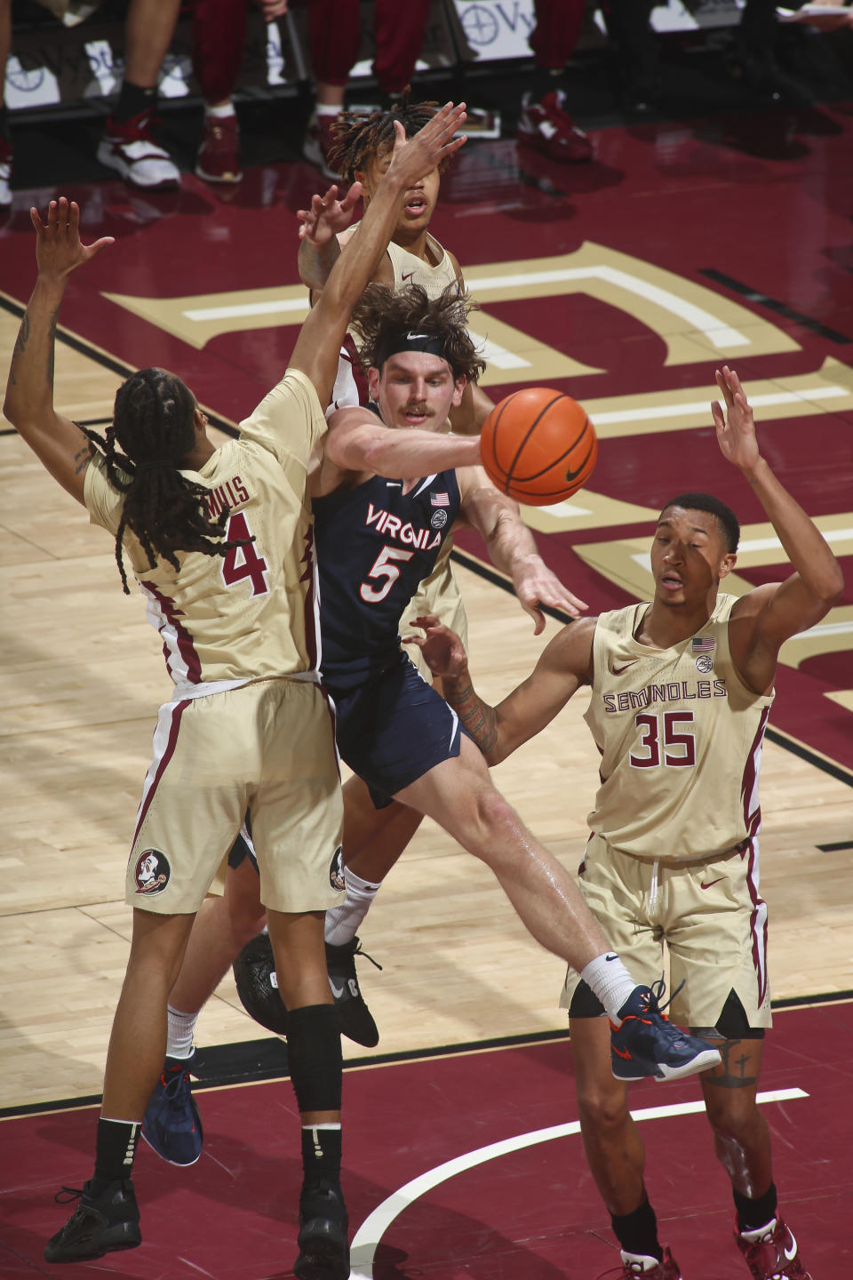 Virginia forward Ben Vander Plas (5) passes the ball as he is triple-teamed by Florida State defenders in the first half of an NCAA college basketball game in Tallahassee, Fla., Saturday, Jan. 14, 2023. (AP Photo/Phil Sears)