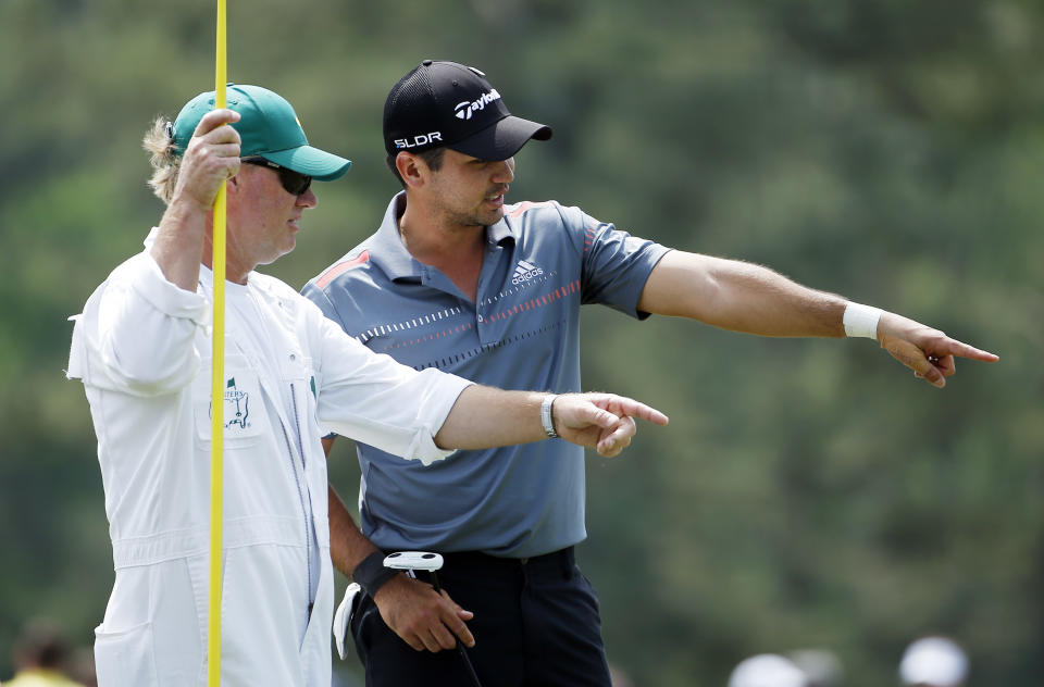 Jason Day, of Australia, talks to his caddie Colin Swatton on the 14th green during the second round of the Masters golf tournament Friday, April 11, 2014, in Augusta, Ga. (AP Photo/Matt Slocum)