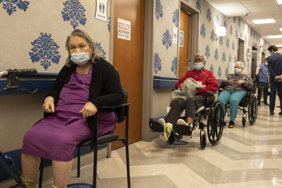 FILE - In this Friday, Jan. 15, 2021 file photo, nursing home residents wait on line to receive a COVID-19 vaccine at Harlem Center for Nursing and Rehabilitation, a nursing home facility in the Harlem neighborhood of New York. After a deadly year in New York’s nursing homes, state lawmakers have passed legislation that could potentially force facility owners to spend more on patient care. (AP Photo/Yuki Iwamura, File)