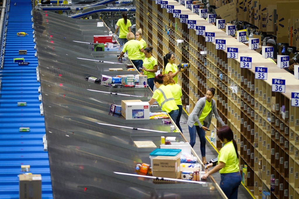 Walmart associates collect items for orders to be packaged at the Walmart e-commerce fulfillment center in Davenport in 2017. The company recently announced that 400 people at the facility would be laid off.