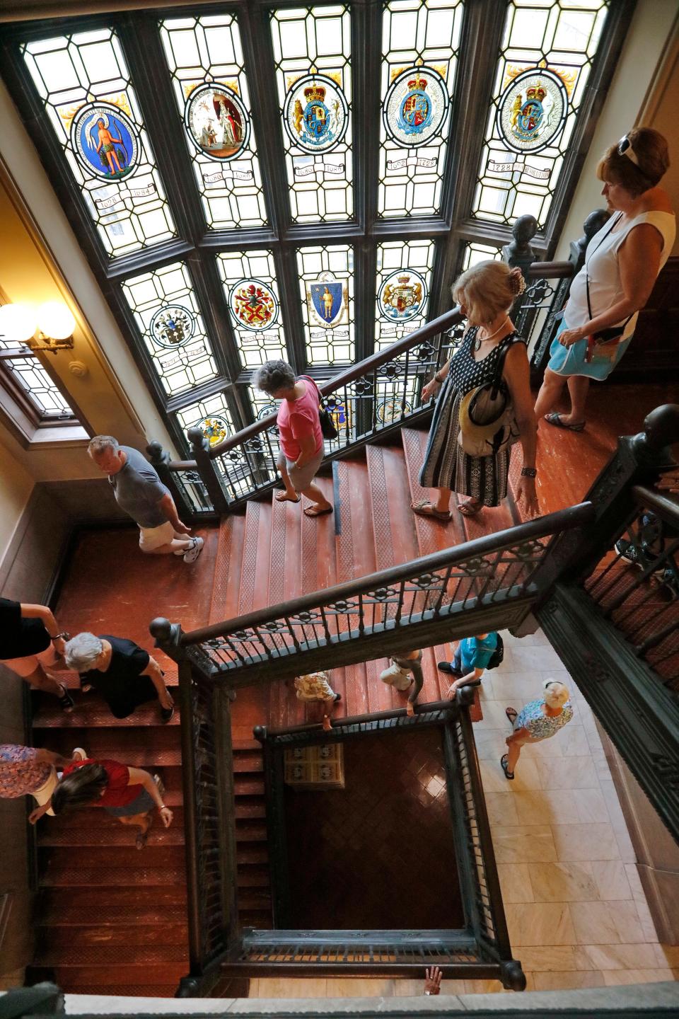 Visitors make their way up the iconic grand staircase at Fairhaven High School with stained glass in the background.  Bob Foster of the Fairhaven High School Alumni Association, gives residents a tour of the historic Fairhaven High School which was donated to the town by Henry H. Rogers in 1906.