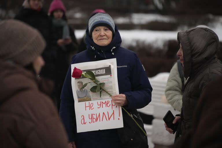 Una mujer sostiene un pequeño cartel con las palabras 