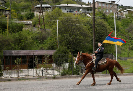 A man holds an Armenian flag as he rides a horse before a rally held by supporters of opposition leader Nikol Pashinyan in the town of Ijevan, Armenia April 28, 2018. REUTERS/Gleb Garanich