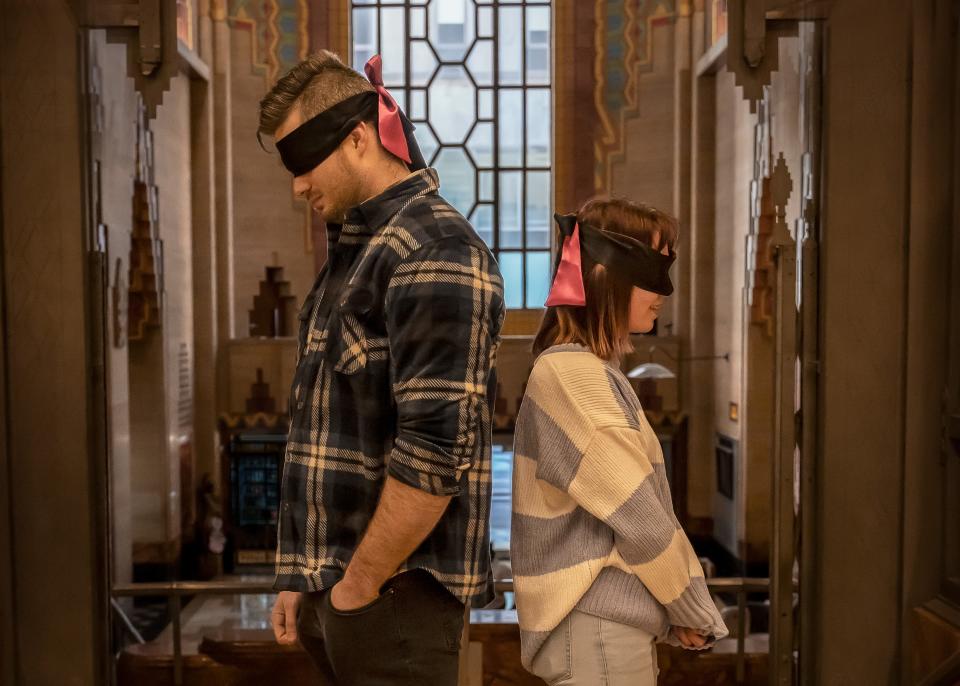 A couple on a blind date stands back-to-back with blindfolds on before the big reveal during K Marie Photography's first Stranger Session in the Guardian Building on Jan.14, 2024.