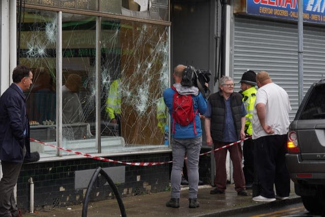 Police officers outside a damaged butchers shop on Murray Street in Hartlepool following an evening of unrest 