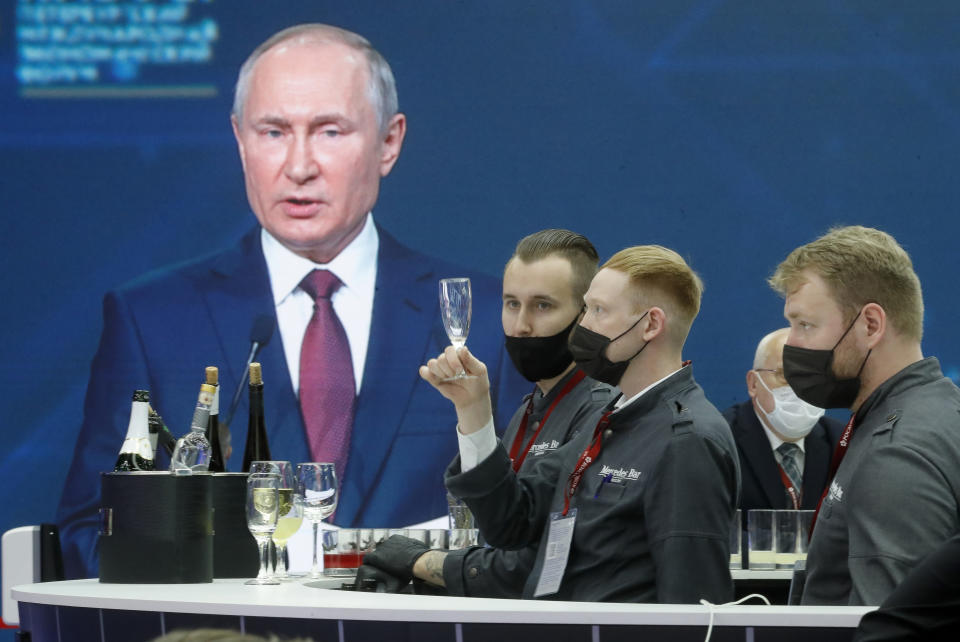 Waiting staff prepare to distribute soft drinks for journalists gathered in the press center to listen to Russian President Vladimir Putin address at the St. Petersburg International Economic Forum in St. Petersburg, Russia, Friday, June 4, 2021. (AP Photo/Dmitri Lovetsky)