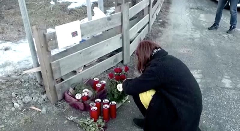 A woman lights a candle after a suspected drunk driver fatally struck a group of German tourists in Lutago