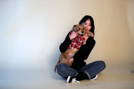 A woman poses for photographs with her pet dog at a pet studio in Seoul, South Korea, January 17, 2019. REUTERS/Kim Hong-Ji