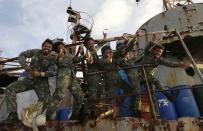 Philippine Marines, who were deployed for almost five months now, pose for a local television news crew aboard the Philippine Navy ship LT 57 Sierra Madre off Second Thomas Shoal (local name Ayungin Shoal) Saturday, March 29, 2014 off South China Sea. China Coast Guard vessel attempted to block the vessel earlier which carried supplies and troops to replace their fellow marines who were deployed for almost five months.(AP Photo/Bullit Marquez)