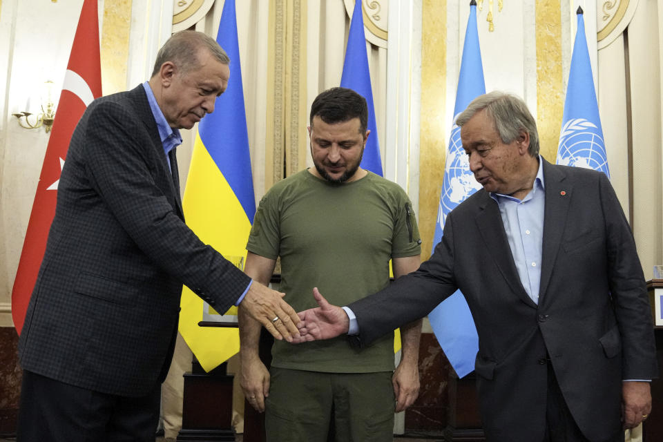 Ukrainian President Volodymyr Zelenskyy, center, watches as Turkish President Recep Tayyip Erdogan, left, and United Nations Secretary General Antonio Guterres shake hands after their meeting in Lviv, Ukraine, Thursday, Aug. 18, 2022. (AP Photo/Evgeniy Maloletka)